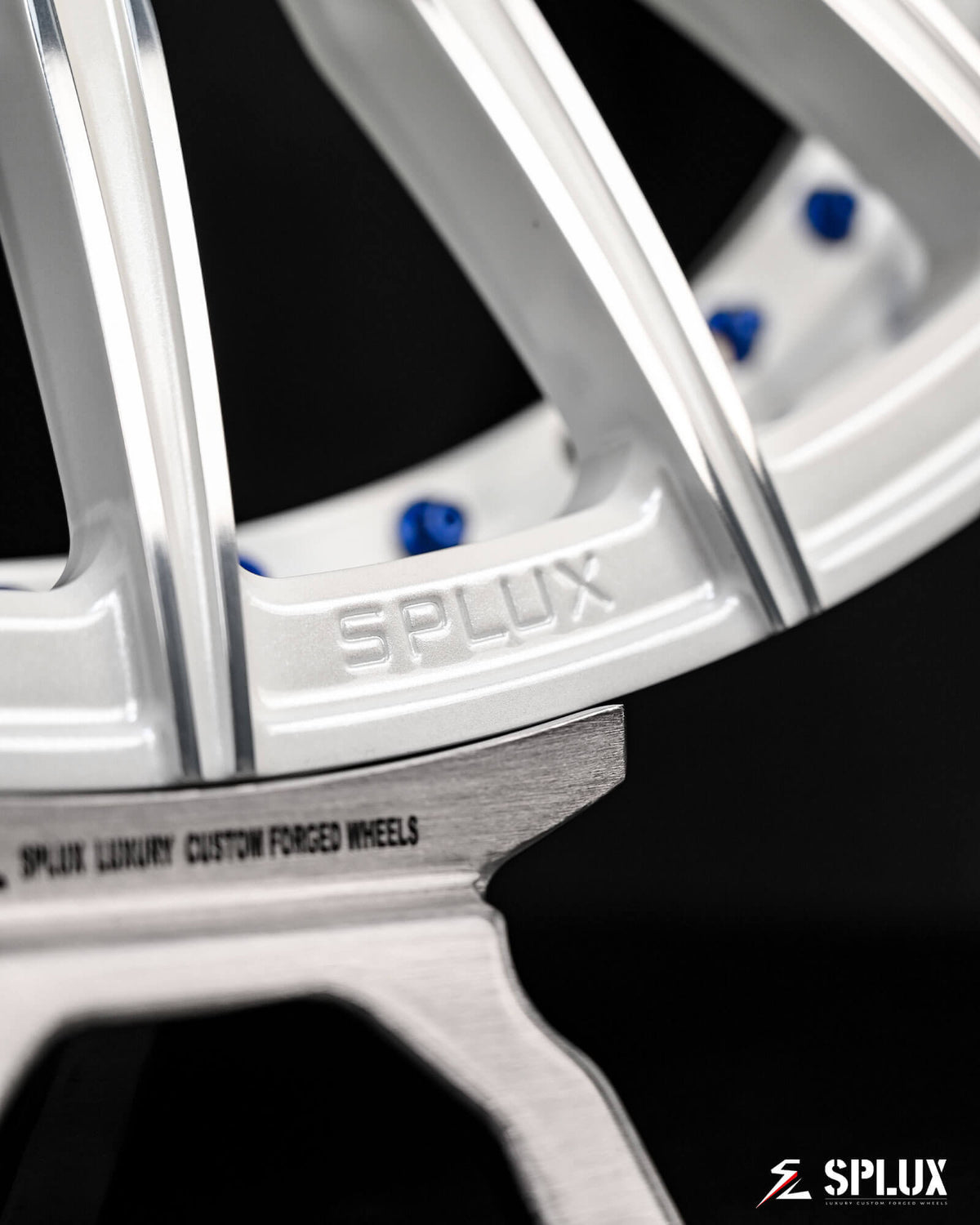 C6 Corvette wheels with blue rivets, a gloss black barrel, and a white multi-spoke design with a machined face.