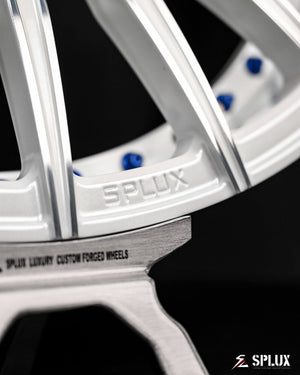 C6 Corvette wheels with blue rivets, a gloss black barrel, and a white multi-spoke design with a machined face.