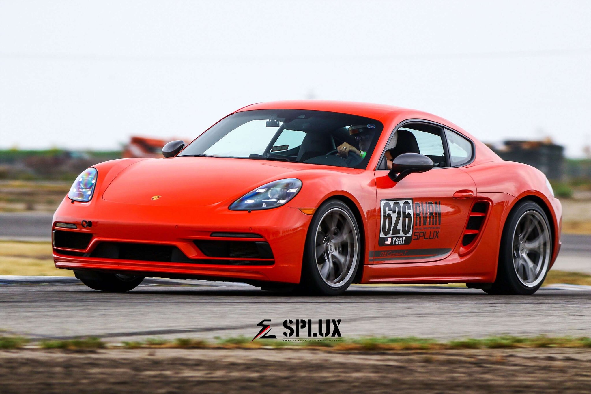 Porsche 718 Cayman in vibrant orange racing on the track, showcasing Splux SL-03R super lightweight forged wheels.