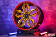 Close-up of the SR-05 wheel showing gloss black barrel, red lip, and yellow spokes on the C7 Z06
