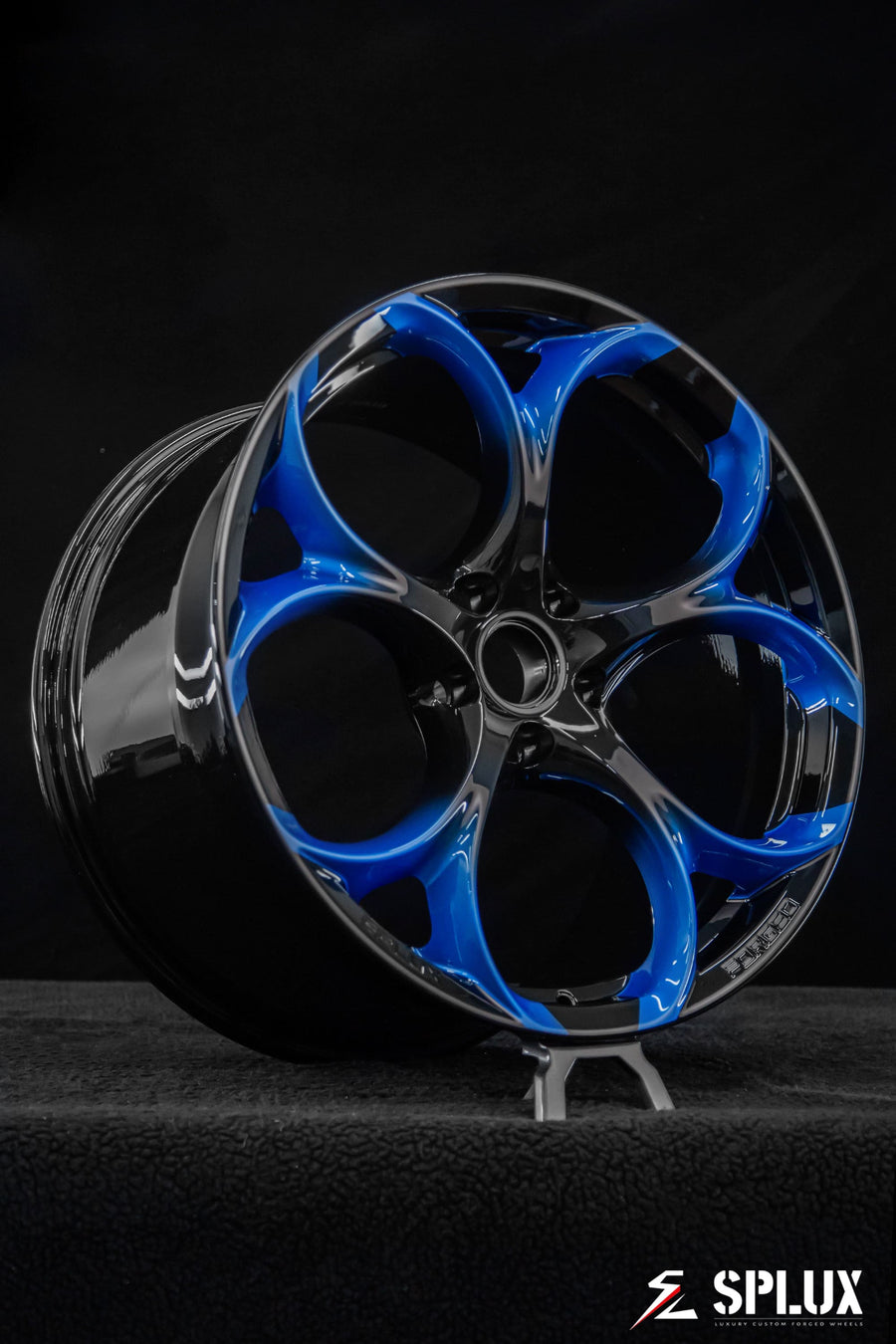Close-up of the SC-07M wheel showing the piano black fade to Riptide Blue and five lug holes