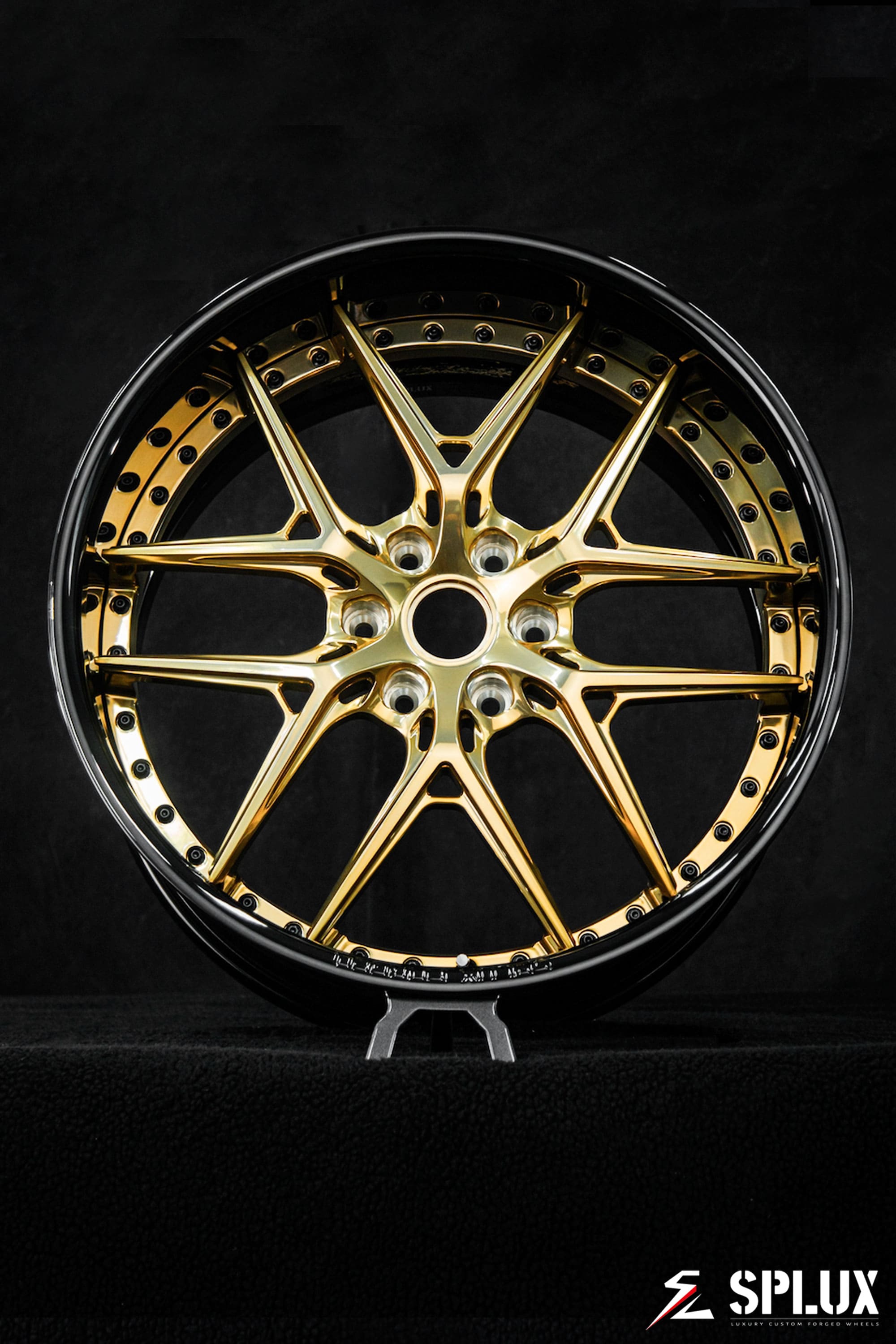 Polished frozen gold spokes against a piano black barrel