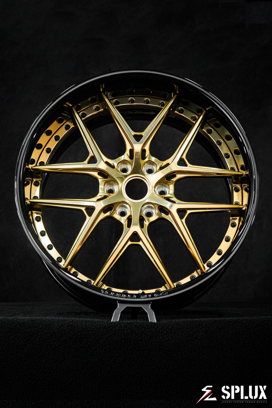 Polished frozen gold spokes against a piano black barrel
